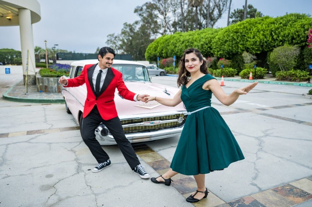 Retro-styled performers dancing beside a vintage car at the Cop Hop gala.